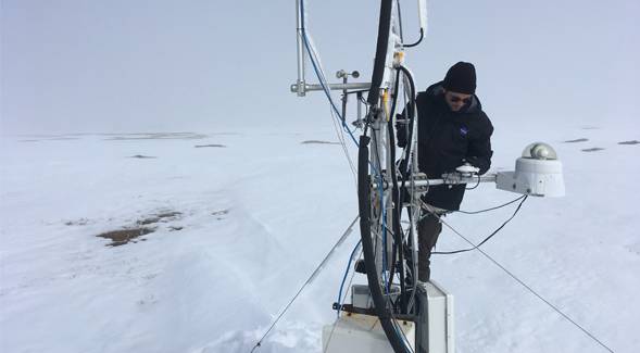 Researcher on boat in arctic ice